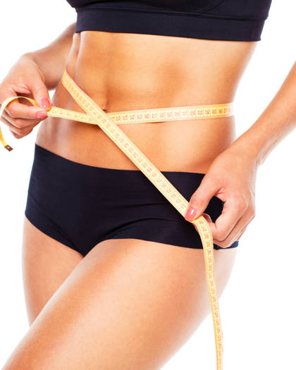 Woman measuring her slim waist after body contouring treatment