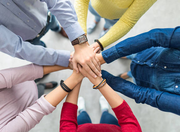 Team members joining hands in unity