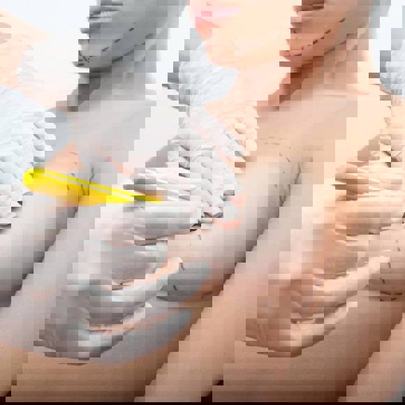 Plastic surgeon marking breast area before augmentation surgery with precision planning