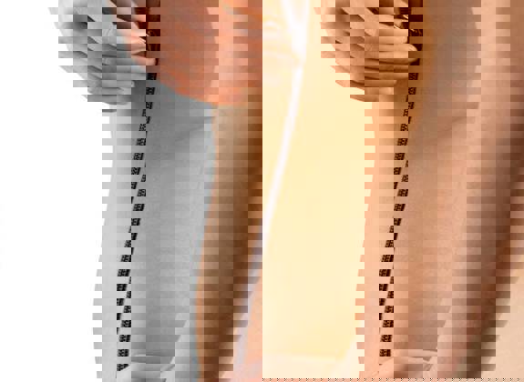 Conceptual image of a woman unzipping her skin along her side, symbolizing body transformation