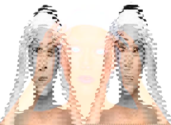 Portrait of a woman gently lifting her eyebrows, demonstration the upper face region 