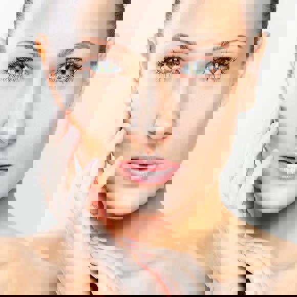 Portrait of a woman with smooth skin and natural makeup, representing facial aesthetics and treatments