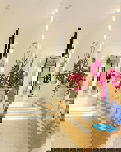 Bright reception area with modern decor and orchid flowers at Opsis Clinical