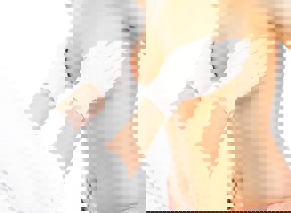 Plastic surgeon examining breast before lift procedure